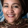 Portrait d’Amina J. Mohammed devant un drapeau des Nations unies