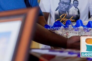 Détails de la cérémonie d’hommage à Jayden, avec un portrait commémoratif et des rubans bleus