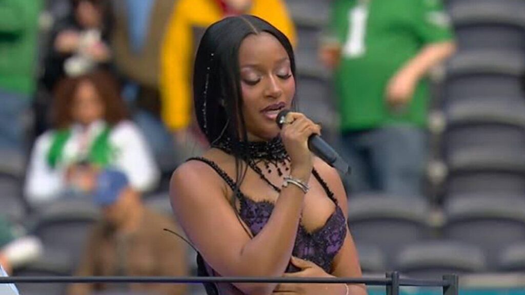 Ayra Starr chante au micro sur le terrain du Tottenham Hotspur Stadium