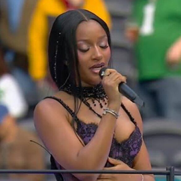 Ayra Starr chante au micro sur le terrain du Tottenham Hotspur Stadium