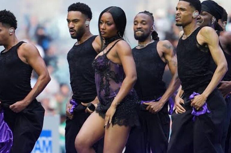 Ayra Starr et ses danseurs sur la pelouse du Tottenham Hotspur Stadium pendant la mi-temps du match NFL
