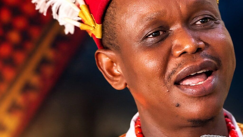 Le chanteur Chinedu en tenue traditionnelle igbo devant un micro de studio