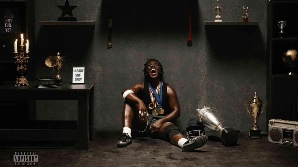 Kweku Smoke assis dans un décor sombre pendant une séance photo