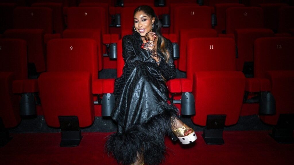 Mo Abudu assise dans une salle de cinéma aux fauteuils rouges